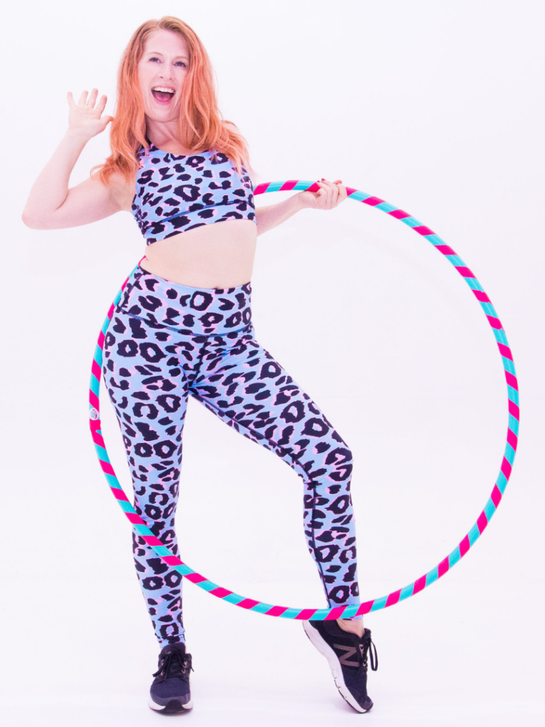 carla, hulafit instructor holds hulafit hulahoop in cool leopard leggings